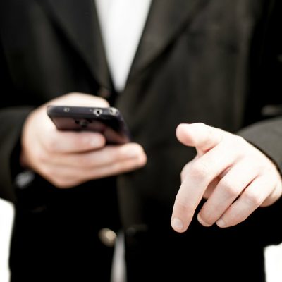 Business man holding a cell phone (image by kev-shine [CC2.0]__via Freestockphotos