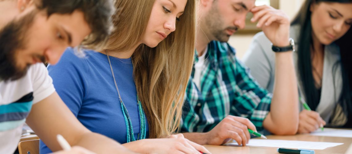 Students having a test in a classroom (adapted) (Image by luckybusiness via AdobeStock)