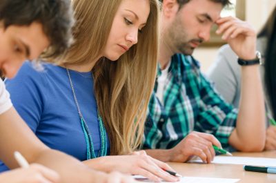 Students having a test in a classroom (adapted) (Image by luckybusiness via AdobeStock)