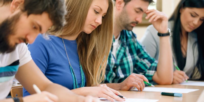 Students having a test in a classroom (adapted) (Image by luckybusiness via AdobeStock)