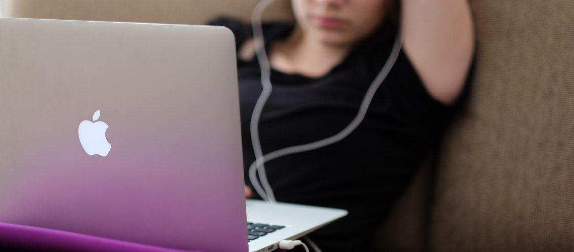 Woman with a MacBook on a sofa (adapted) (Image by Steinar Engeland [CC0 Public Domain] via Unsplash)