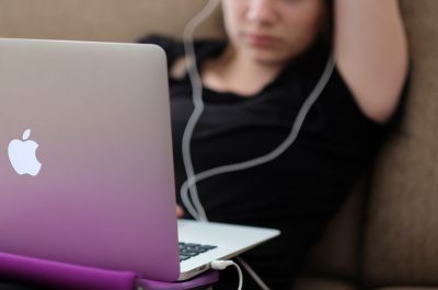 Woman with a MacBook on a sofa (adapted) (Image by Steinar Engeland [CC0 Public Domain] via Unsplash)