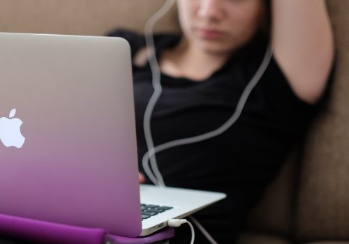 Woman with a MacBook on a sofa (adapted) (Image by Steinar Engeland [CC0 Public Domain] via Unsplash)