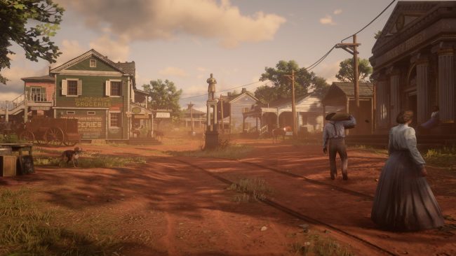 Die Stadt Rhodes mit bunt gestrichenen Häusern und rötlicher Erde bei Tag im Spiel Red Dead Redemption 2