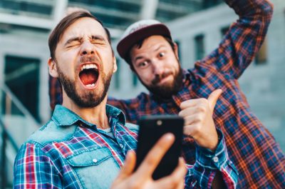 zwei Männer haben Spaß mit einem Smartphone