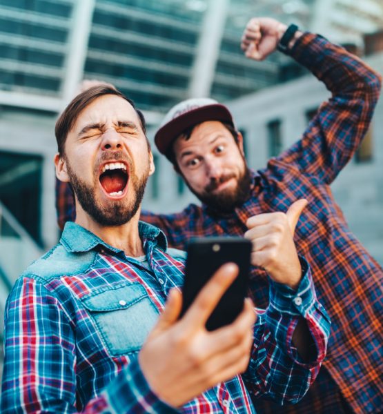 zwei Männer haben Spaß mit einem Smartphone