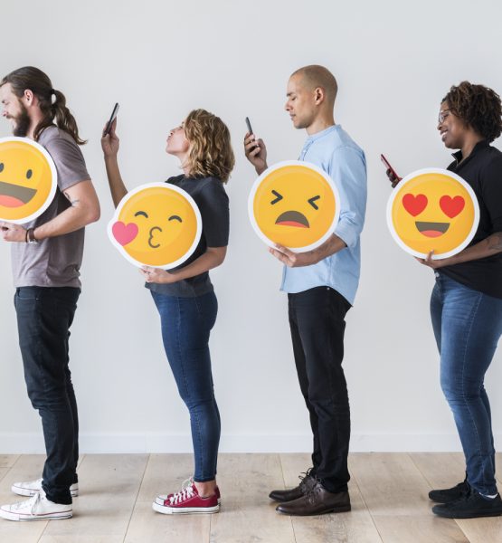 4 junge Menschen mit Emojis und Smartphones.