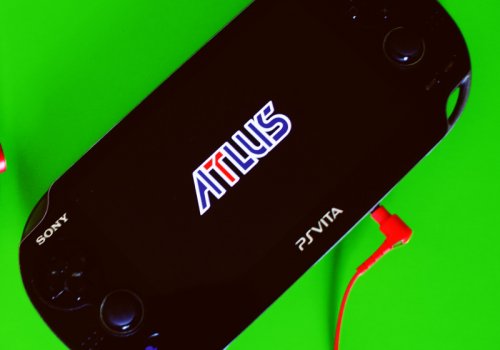 Die Playstation Vita mit einem Spiel von Atlus