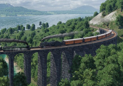 Zwei Dampfloks fahren in Transport Fever 2 auf einer großen Steinbrücke in idyllischer Insellandschaft aneinander vorbei.