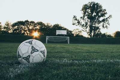 Ein Ball liegt auf dem Rasen. Titelbild für die besten Fußballpodcasts / Image by Markus Spiske via Pexels