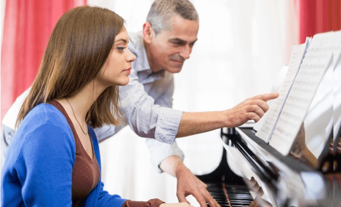 Ein Klavierlehrer hilft beim Lernen des Instruments