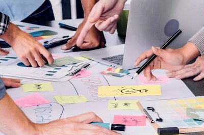 Team mit Laptop und vielen Notizen - Titelbild zu " nootiz- Kommunikation im Projektteam vereinfachen" / Foto von © weedezign via Adobe Stock