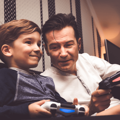 Kleiner Junge und älterer Mann spielen zusammen Videospiele für Anfänger bzw. Non-Gamer
