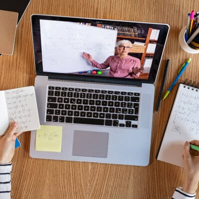 Hände die Notizen machen vor Laptop wo Video läuft - Titelbild zu "Tipps für erfolgreiches Online-Studium" / Foto von © Rido via Adobe Stock