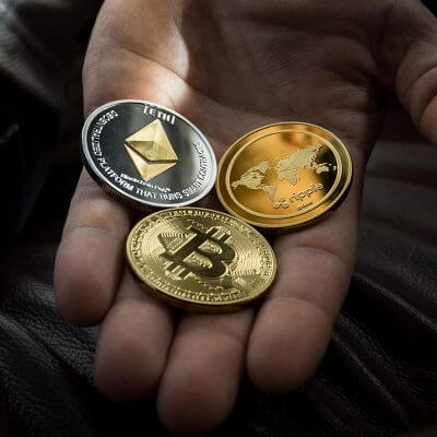 Bild von symbolischen Kryptowährungen auf einer geöffneten Handfläche