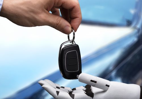 Ein mensch gibt einem Roboter den Autoschlüssel