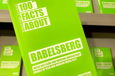 Das Buch "100 Facts about Babelsberg" in der Hand.
