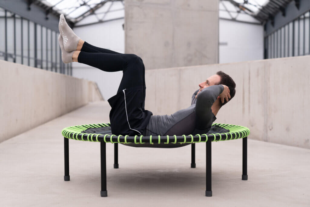 Ein Mann macht Fitnessübungen auf dem Trampolin