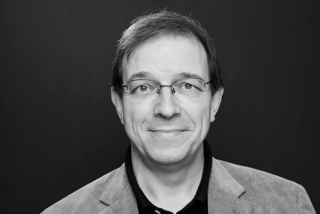 Andreas Eschbach aus der Frontalen Ansicht, mit Brille und Hemd