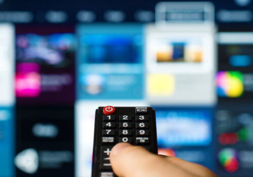 Internetfernsehen Coverbild: Mann hält Fernbedienung.