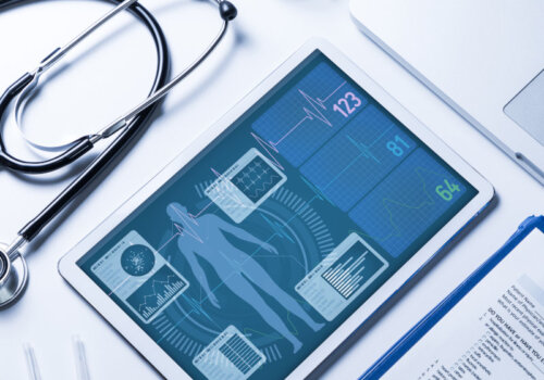 Beitragsbild Elektronische Patientenakte: Stethoskop, Tablet, Laptop und Fragebogen auf einem weißen Tisch.