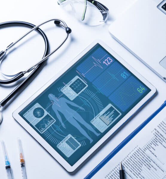Beitragsbild Elektronische Patientenakte: Stethoskop, Tablet, Laptop und Fragebogen auf einem weißen Tisch.