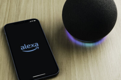 Ein smarter Lautsprecher Amazon Echo und ein Smartphone mit geöffneter Alexa-App.