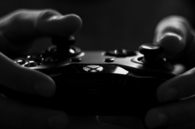 Titelbild zu "Was soll ich spielen?" zwei Händen halten einen XBox Controller - Schwarz weiß Foto von lalesh aldarwish von Pexels
