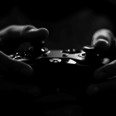 Titelbild zu "Was soll ich spielen?" zwei Händen halten einen XBox Controller - Schwarz weiß Foto von lalesh aldarwish von Pexels