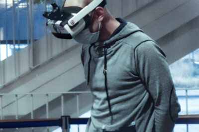Ein Mann, der Maske und VR-Brille in seiner Arbeitsumgebung trägt.