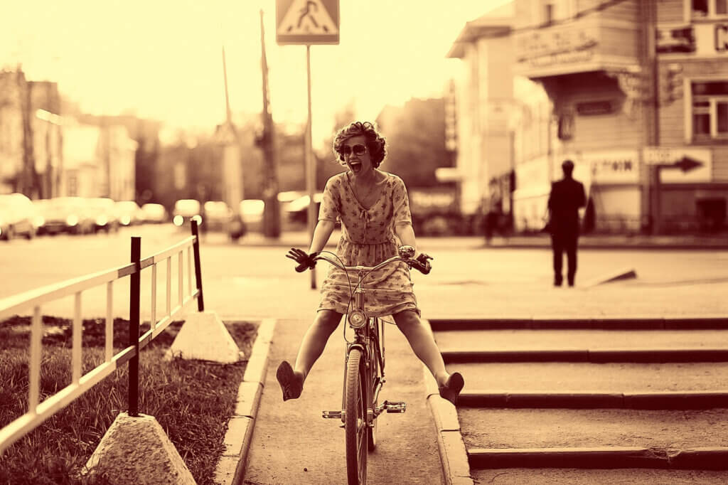 Eine Frau, die viel Spaß am Radfahren hat. Ein Sepia-Effekt lässt das Bild deutlich älter wirken.