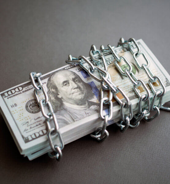 Geldbündel Dollar von Kette umwickelt, abstrakte Darstellung von eingefrorenen Konten und Geldströmen