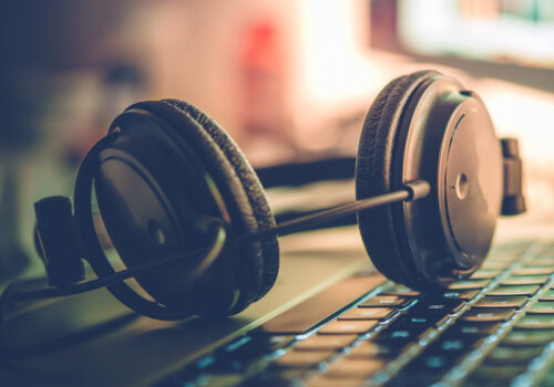 Ein Kopfhörer, der auf der Tastatur eines Laptops liegt.