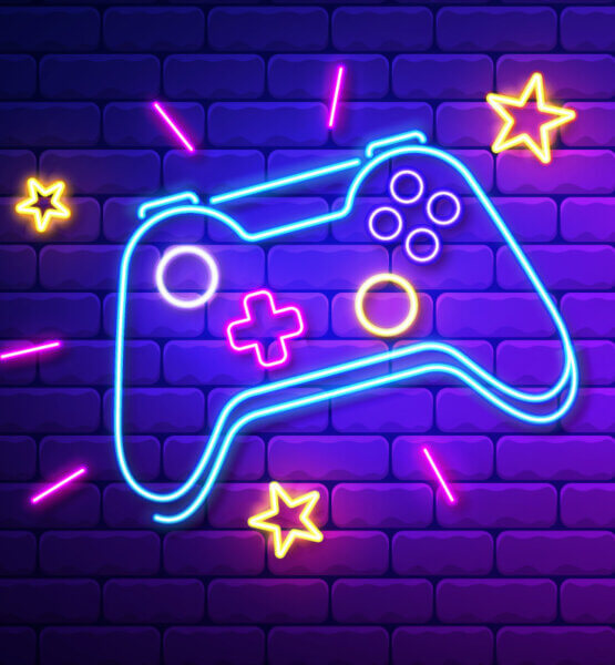 Eine Neonreklame in Form eines klassischen Gaming-Controllers auf einer geziegelten Mauer. Dazu auch einige Neon-Sterne.