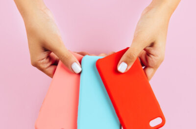Zwei Hände halten drei verschiedenfarbige Handyhüllen ausgefächert zur Auswahl hin.