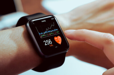 Eine Smartwatch am Handgelenk, die gerade Gesundheitsdaten anzeigt. Unter anderem den Kalorienverbrauch.