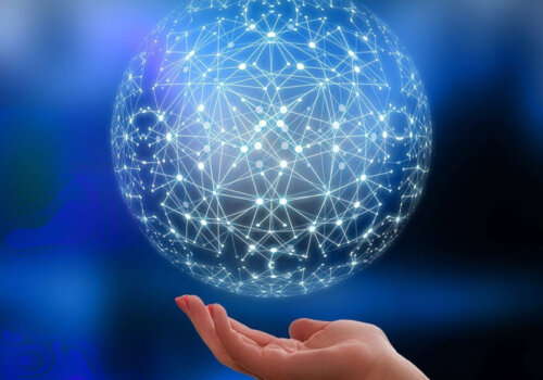 Eine geöffnete Hand über der eine virtuell wirkende Kugel aus durch Lichtstrahlen verbundenen Knotenpunkten schwebt.