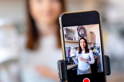 Eine junge Frau nimmt in ihrer Küche hochkant ein Video für Instagram auf