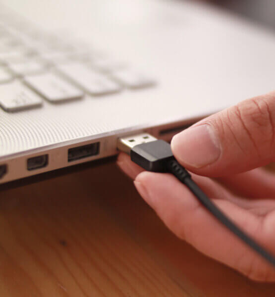 Beitragsbild 7 lustige USB-Gadgets: Nahaufnahme einer Hand, die das Datenkabel in den USB-Anschluss einsteckt