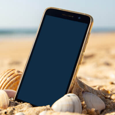 Handy liegt im Strand, ist Sand drin? Da könnte das beste Handy Zubehör für den Urlaub aushelfen