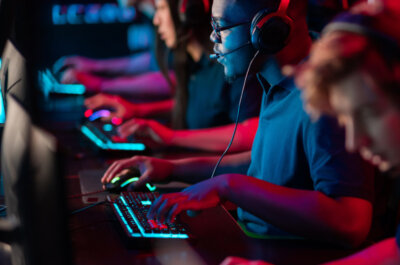 Ein E-Sport Team spielt auf leuchtenden Tastaturen ein Competitive Game.