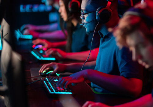 Ein E-Sport Team spielt auf leuchtenden Tastaturen ein Competitive Game.