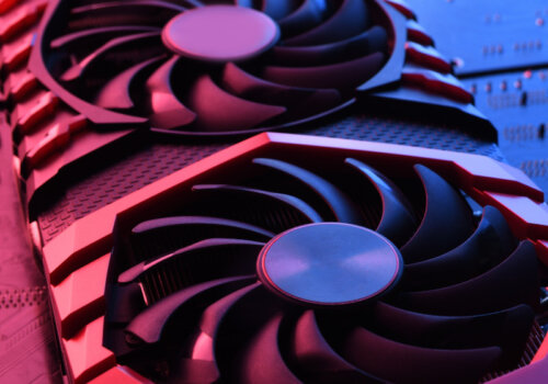 Eine Grafikkarte mit rotem und blauen Licht in Szene gesetzt. Im Hintergrund erkennt man ein Mainboard.