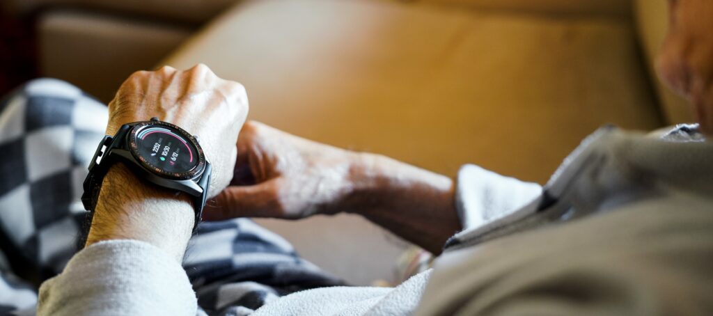 Ein älterer Mann schaut auf die Vitaldaten seiner Smartwatch.