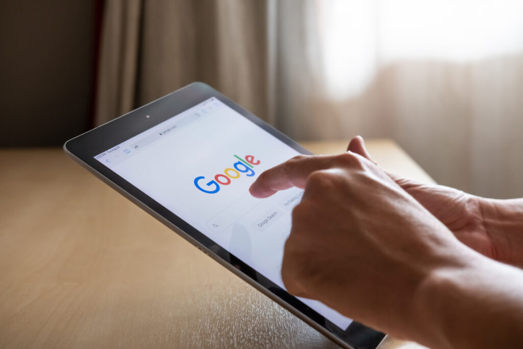 Eine Person surft auf einem Tablet die Google-Suche an.