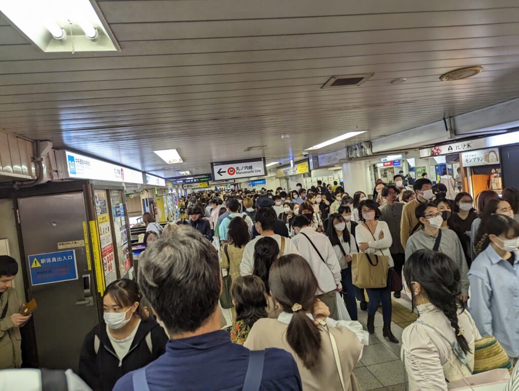 Riesige Menschenmassen bewegen sich durch die Bahnhofsgänge in Ikebukuro