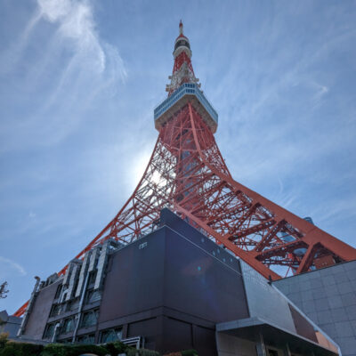 Der rote Tokyo Tower mit Sonne im Hintergrund.