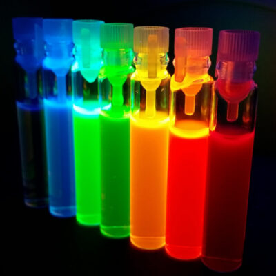 Mehrere leuchtende Flüssigkeiten verschiedenster Farben in Reagenzgläsern.