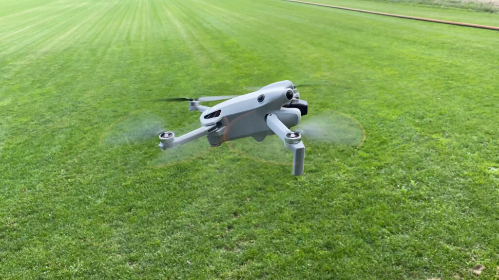 Eine kleine Drohne fliegt über eine sehr weitläufige Wiese.