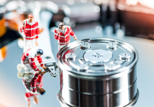 Modellfiguren eines Erste-Hilfe-Teams stehen auf einer Festplatte und versuchen sie zu "retten".